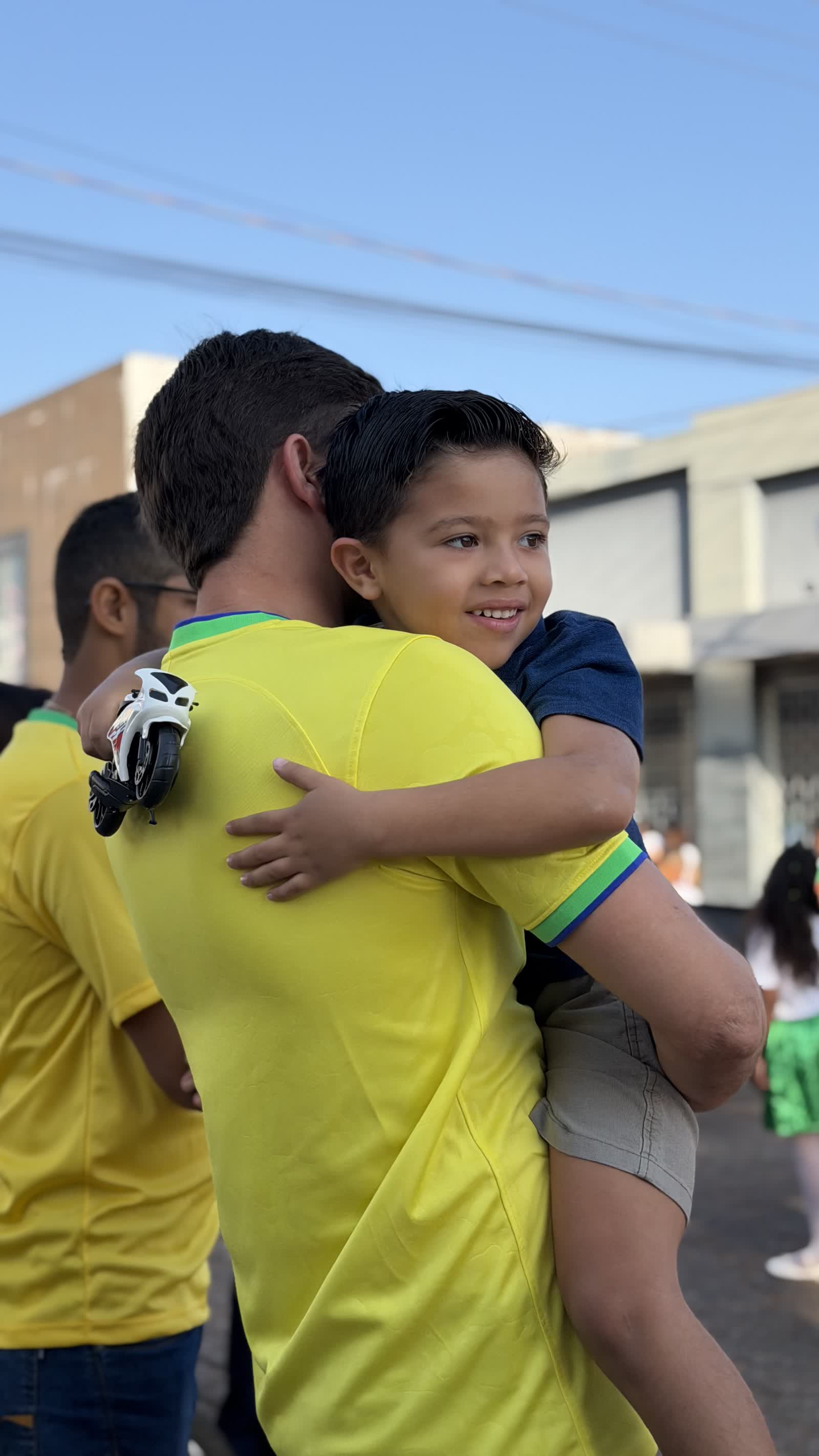 Ikaro Barbosa com um menino no colo durante caminhada