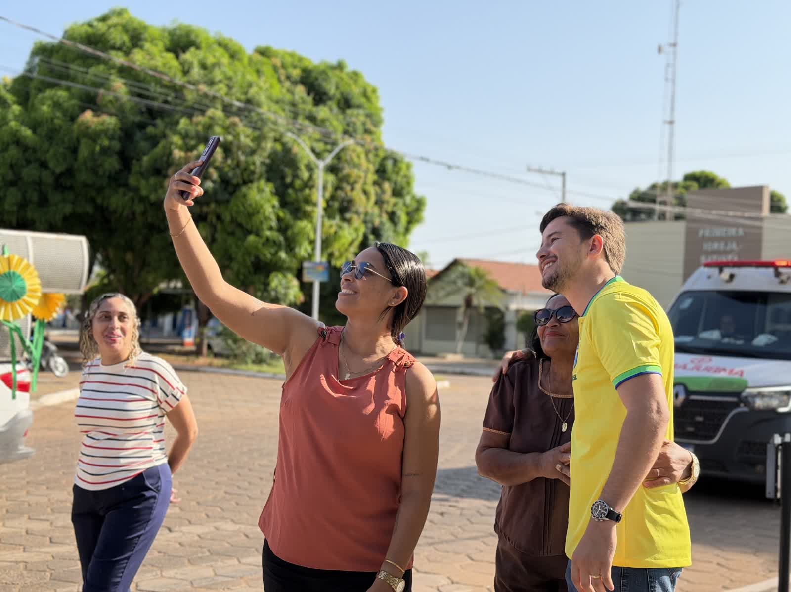 Ikaro Barbosa tirando selfie com apoiadoras na praça durante o dia