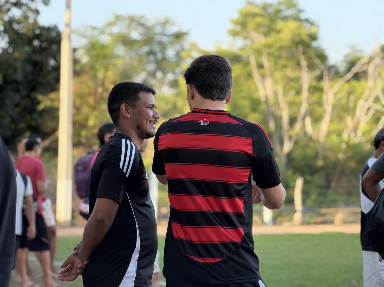 Ikaro Barbosa conversando com um jogador no campo de futebol